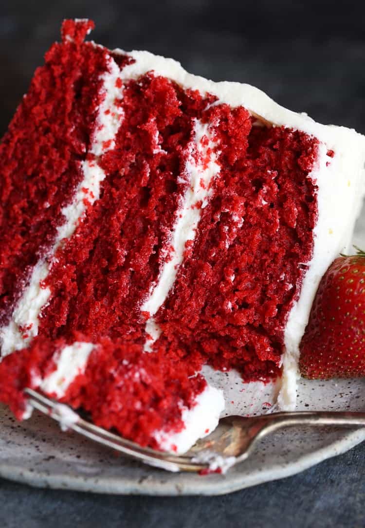 Slice of red velvet cake with a fresh strawberry.