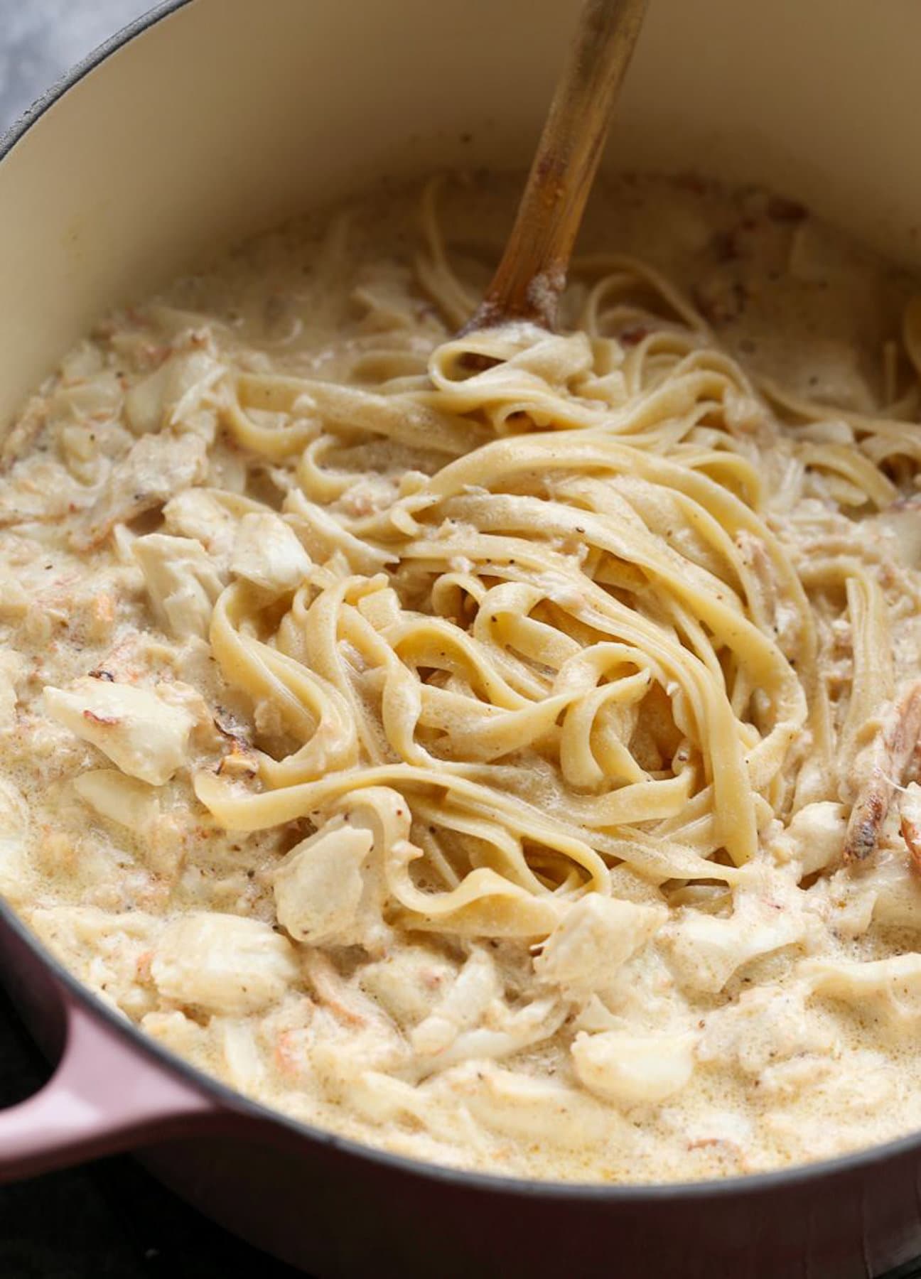 Alfredo sauce mixed into pasta with crab