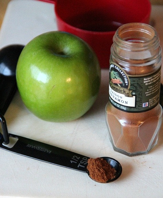 Granny smith apple and a jar of ground cinnamon