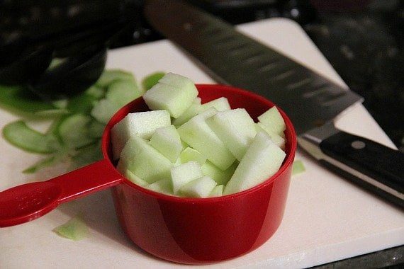 Diced peeled apples in a measuring cup