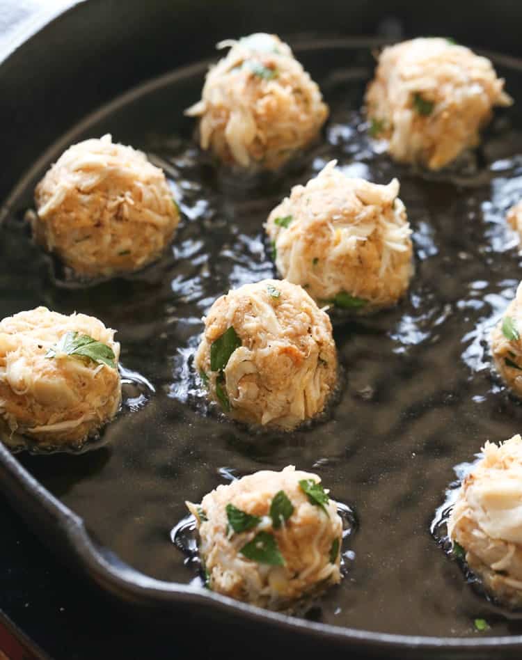 Frying crab balls in oil in a cast iron skillet