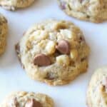 Homemade Sausalito cookies with chocolate chips and macadamia nuts on white parchment paper.