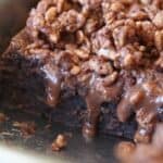 Nutella crunch cake with Nutella topping dripping from under the crunch layer.