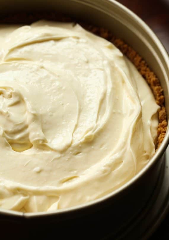 Cheesecake filling poured into a pan filled with graham cracker crust.