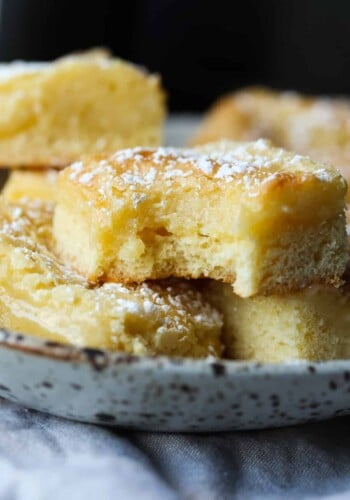 Slices of German butter cake on a plate with a bite taken out of the top slice.