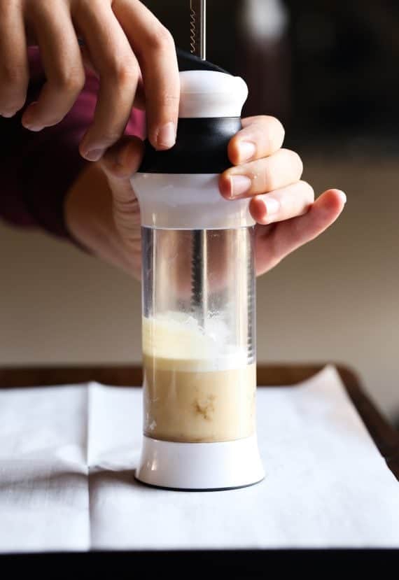 A cookie press with dough on a baking sheet