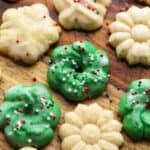 Assorted spritz cookies in different Christmas shapes on a countertop.