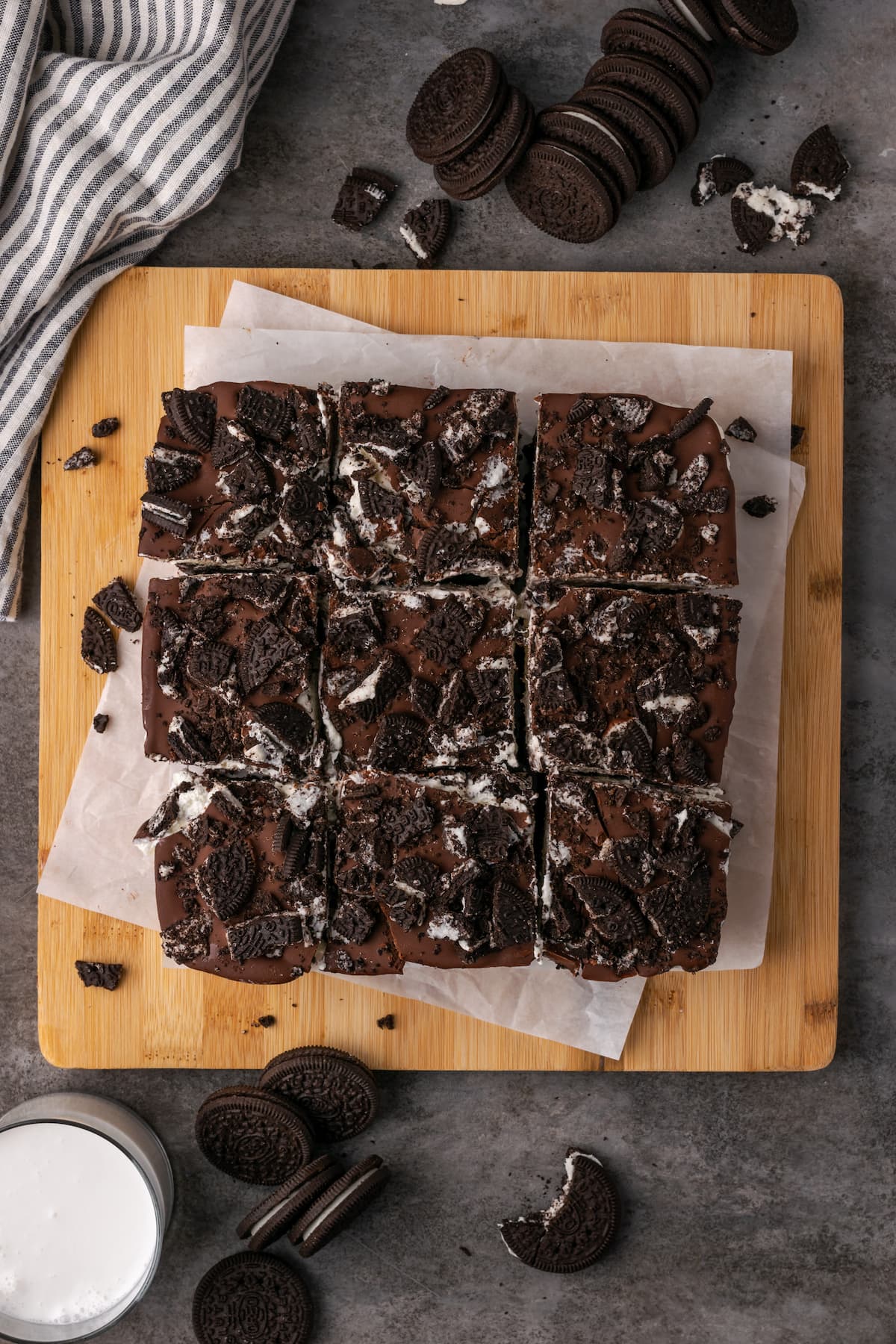 Overhead view of Oreo brownies cut into squares on a wooden cutting board.
