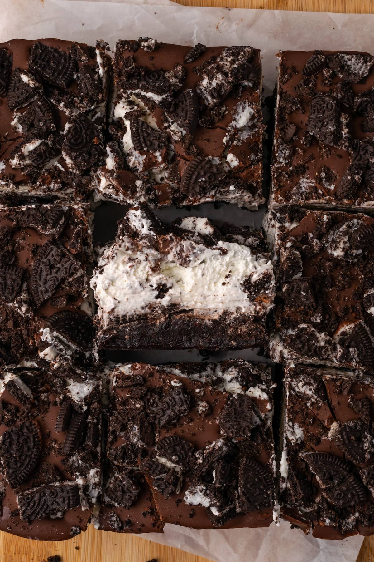 Oreo brownies cut into squares, with one brownie turned on its side to reveal the frosting and chocolate layers.