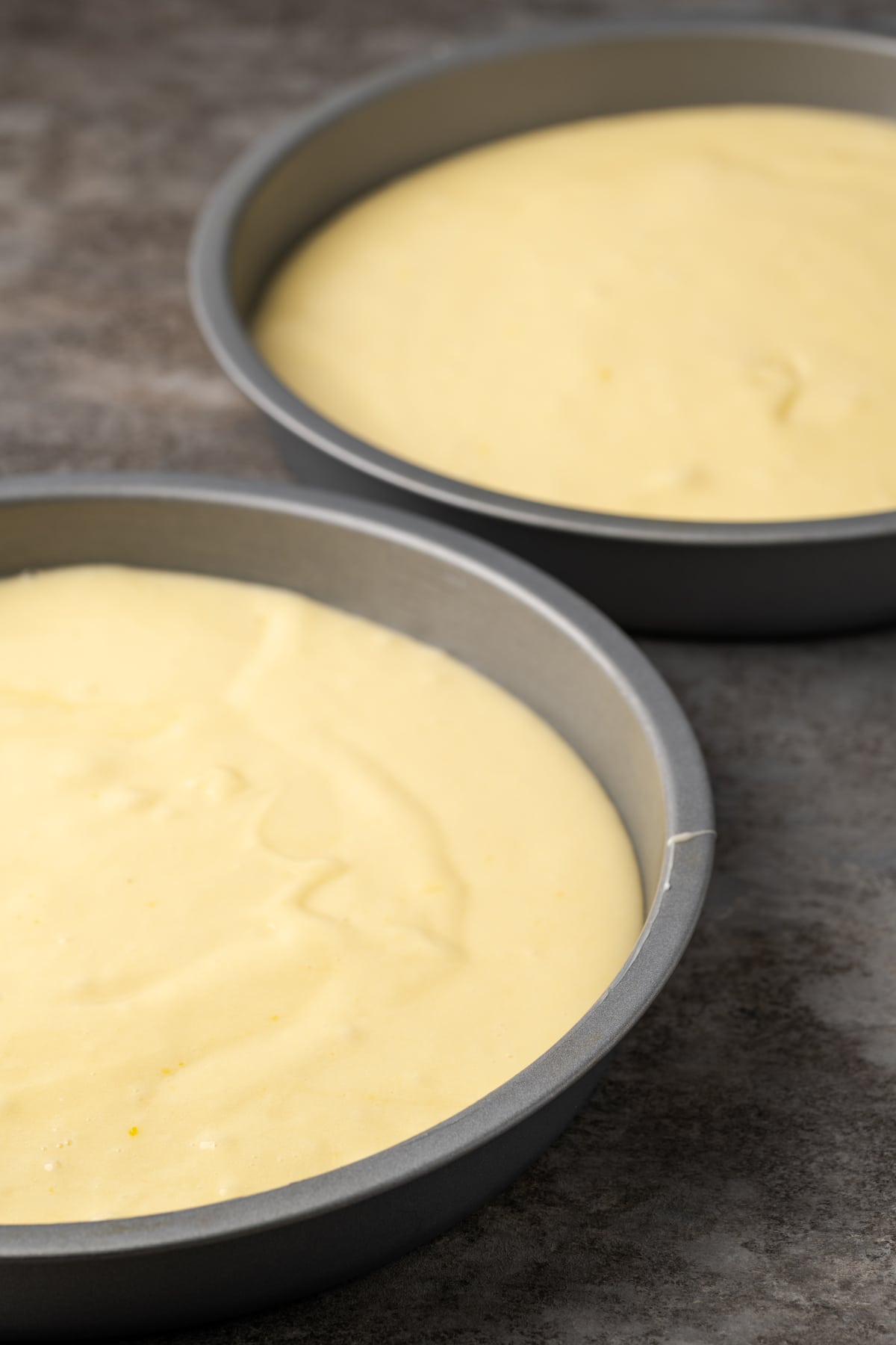Two round cake pans filled with lemonade cake batter.