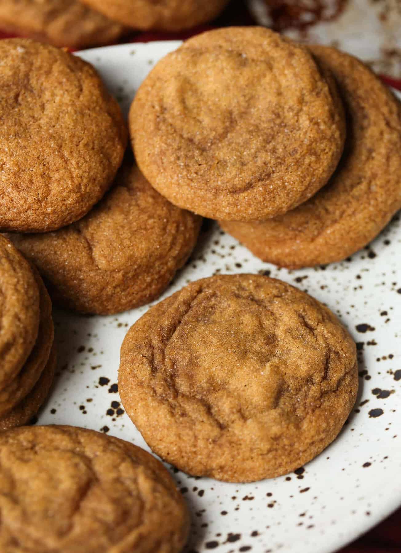 Chewy molasses cookies scattered on a plate.