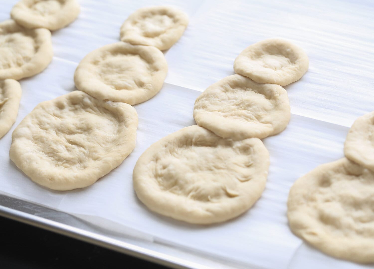 pizza dough split into parts laid out in snowman shape