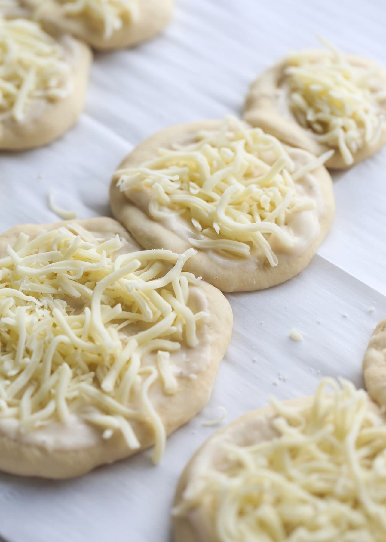 Pizza dough with cheese laid on top