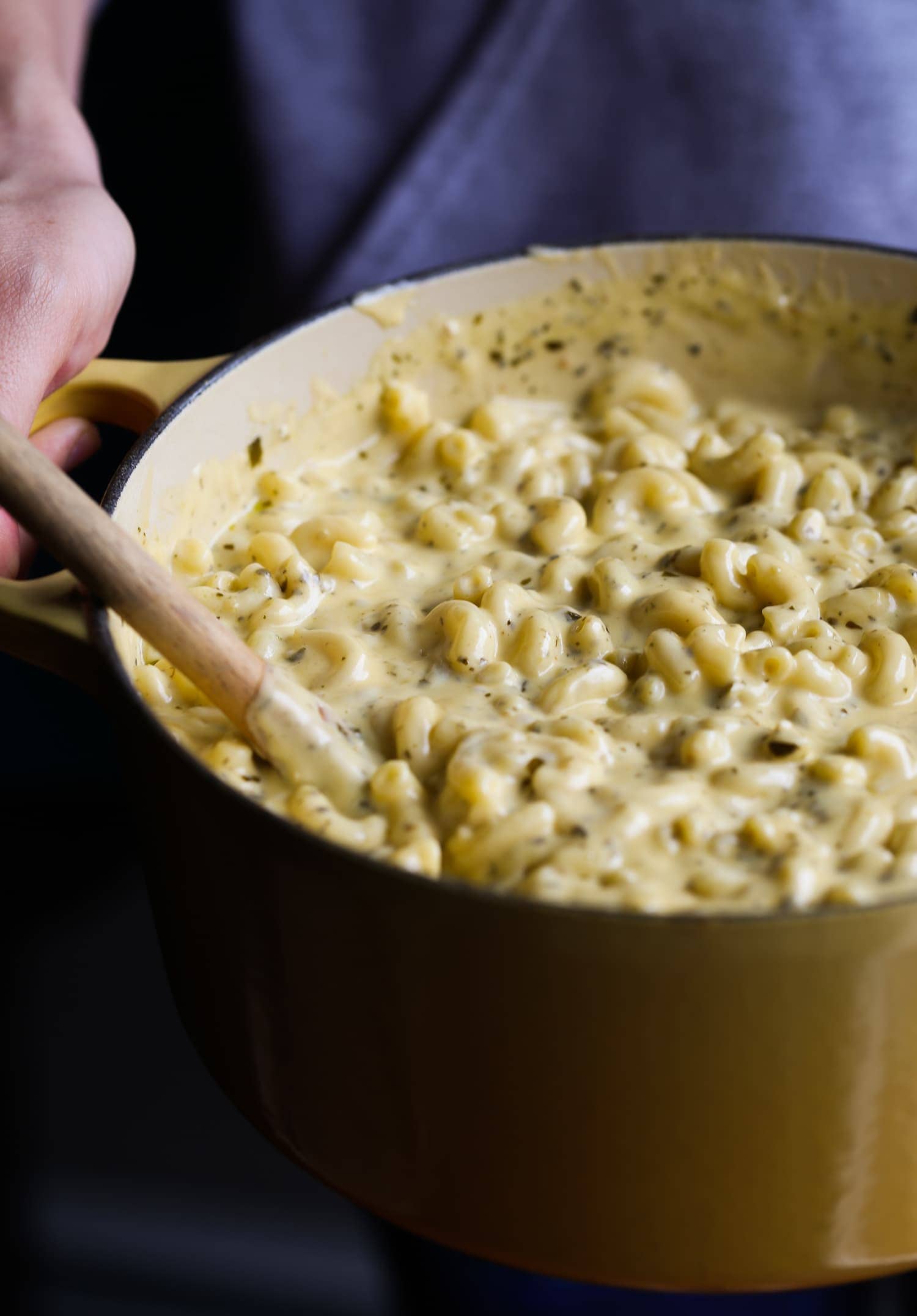 A large pot filled with creamy pesto mac and cheese pasta