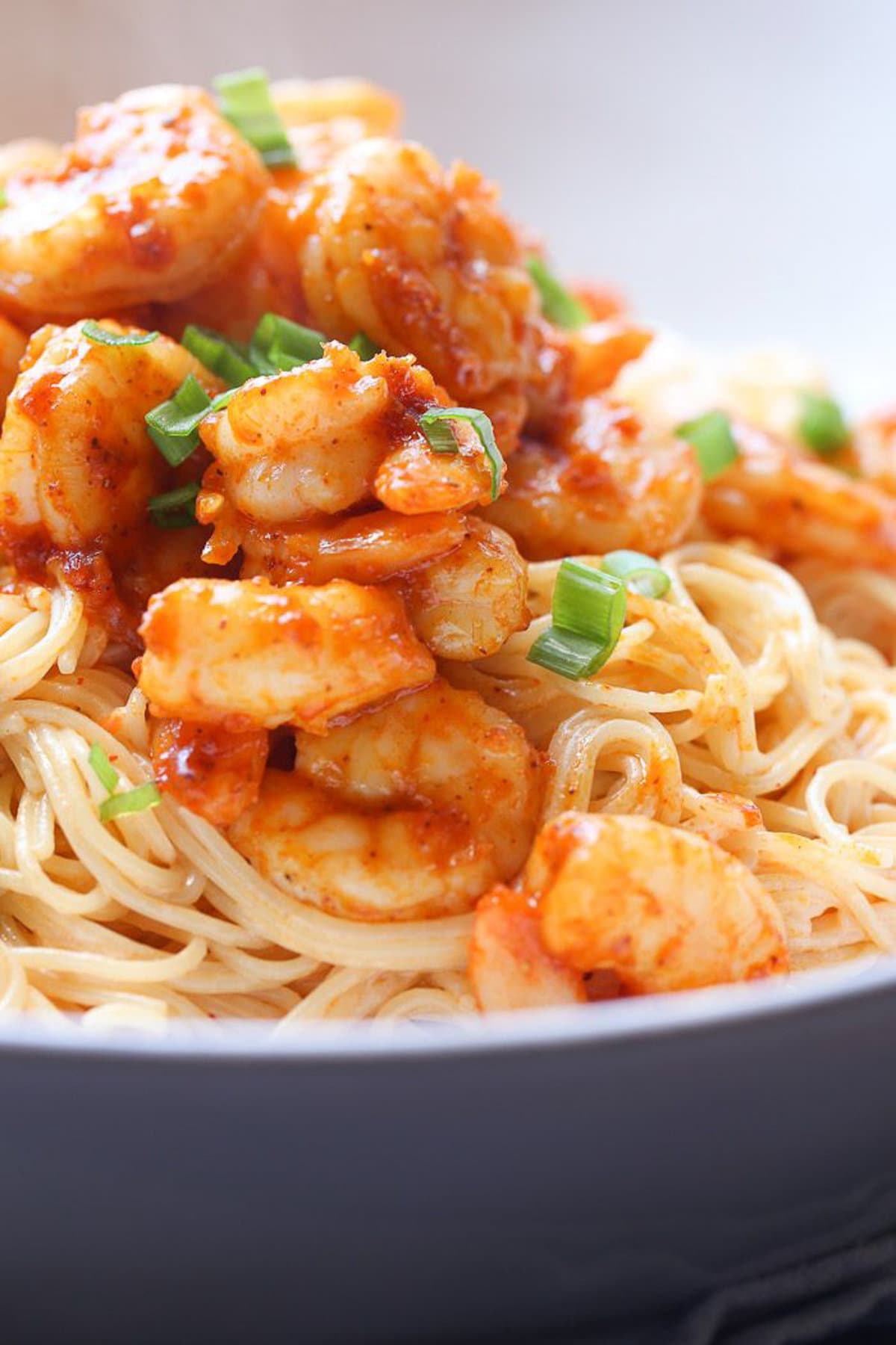 Garnished chicken and shrimp on noodles