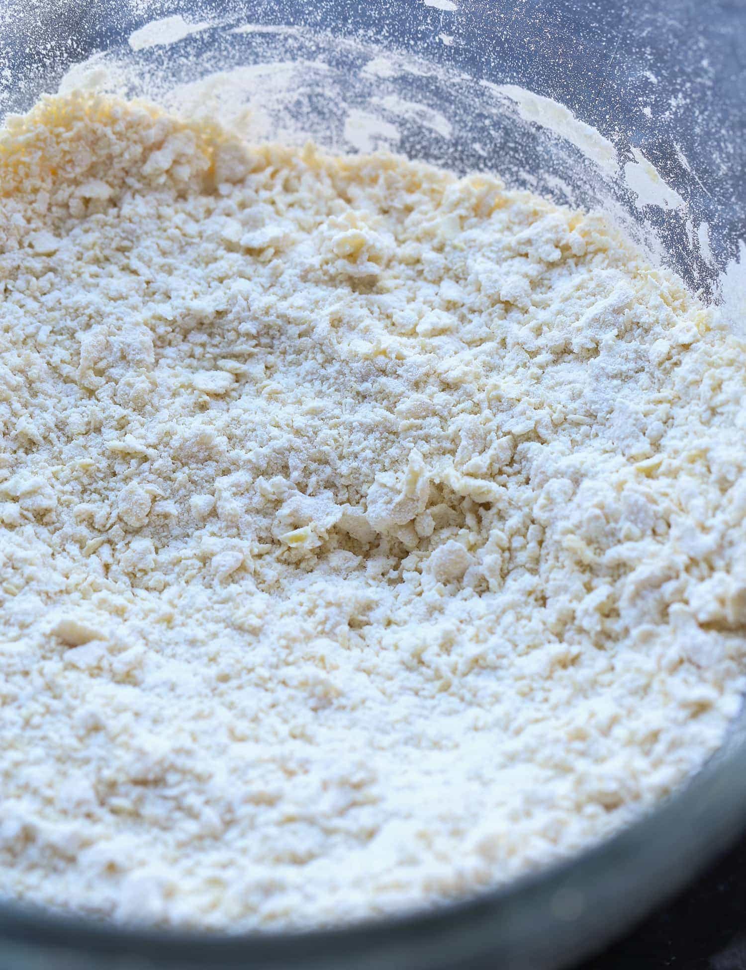 Eggs and flour in a mixing bowl forming small clumps
