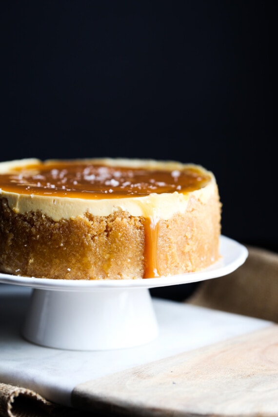 Caramel Instant Pot cheesecake on a white cake stand.