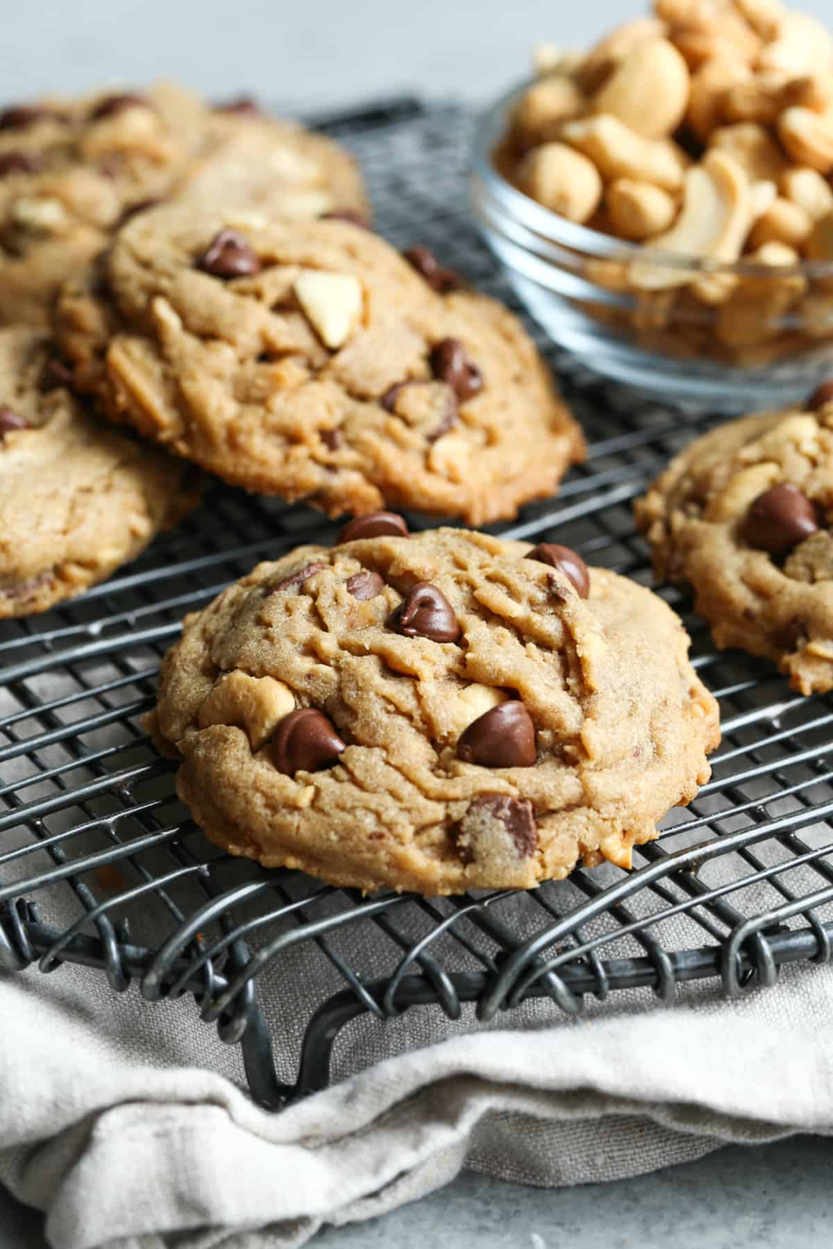 Cookies with cashews, toffee, and chocolate chips made with brown butter on a wire rack