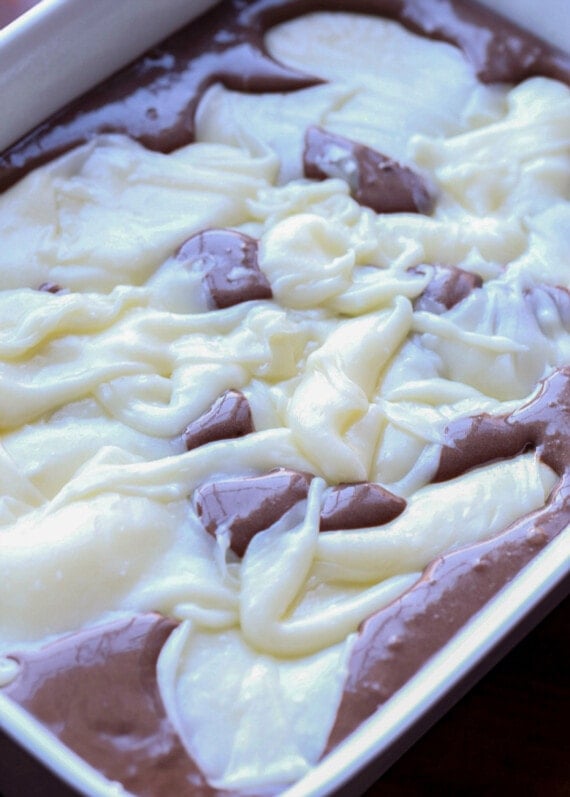 A cream cheese mixture poured over chocolate cake batter.