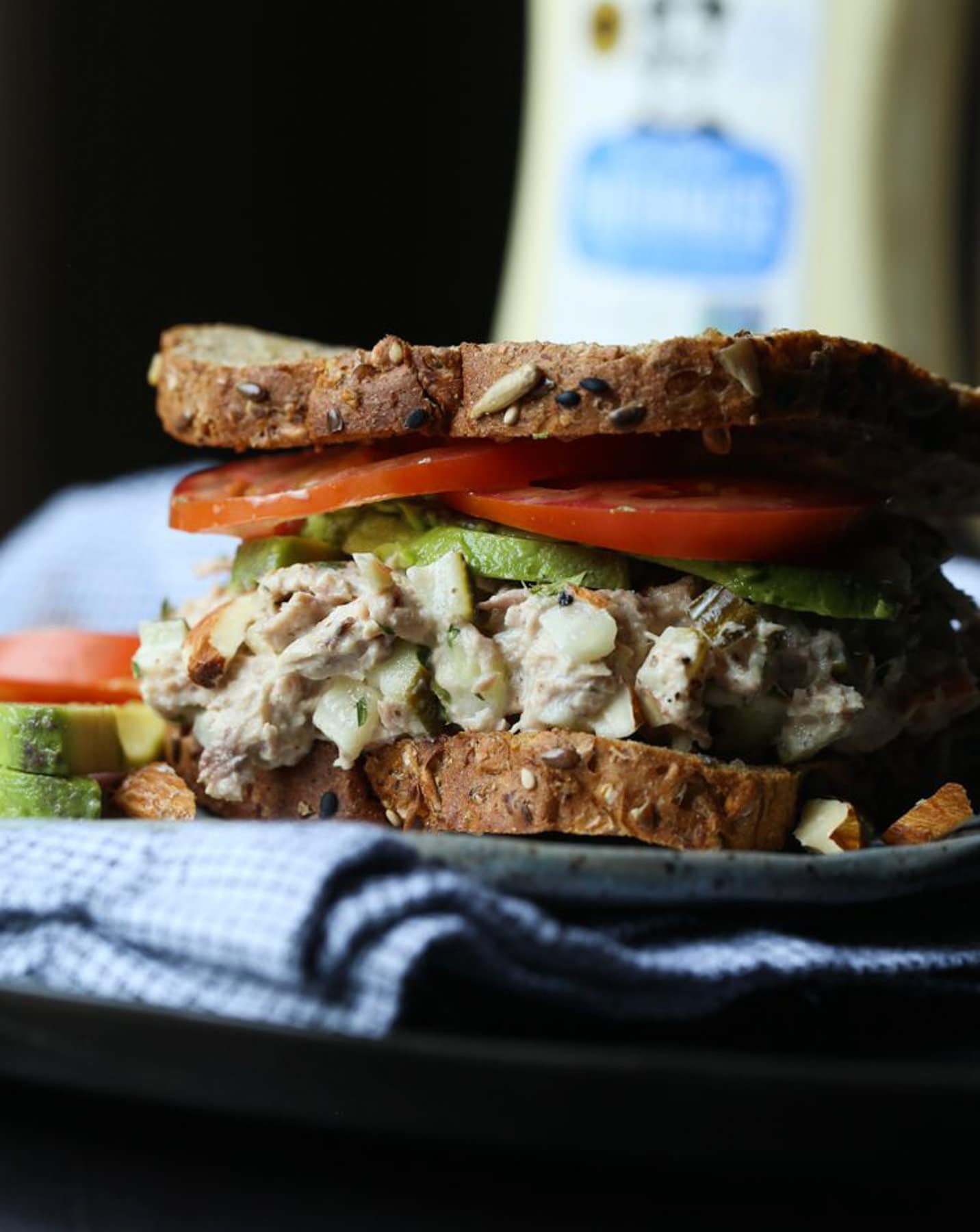 Tuna Salad on a sandwich with avocado and tomatoes