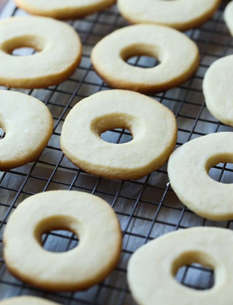 Baked cutout vanilla cookies on a wire rack.