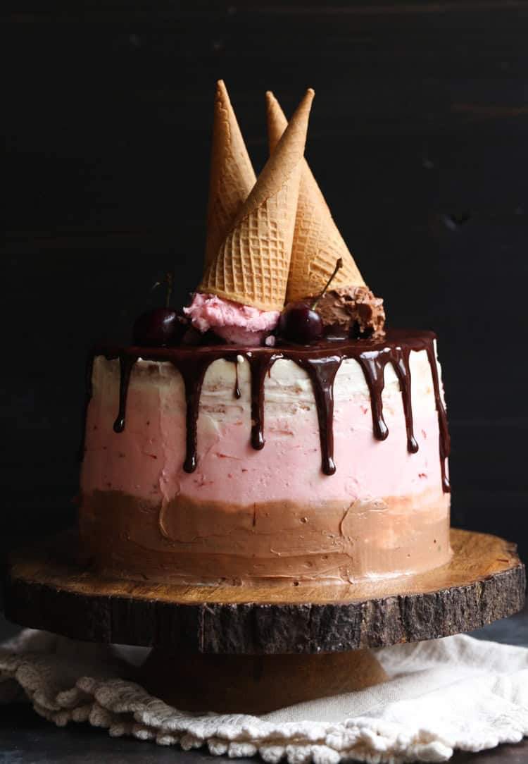 Neapolitan Cake topped with three upside-down ice cream cones.