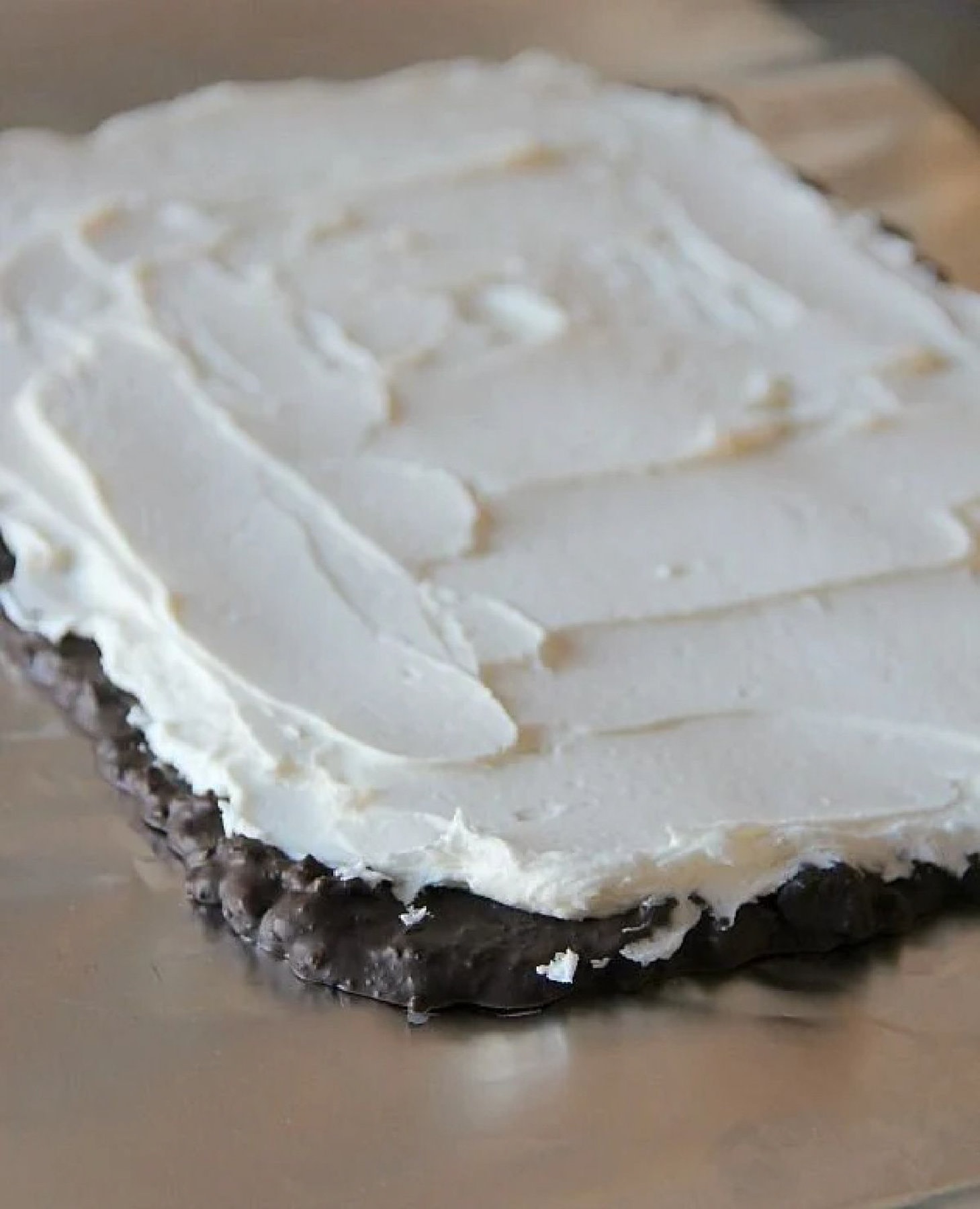 Homemade whipped cream spread on frozen bark