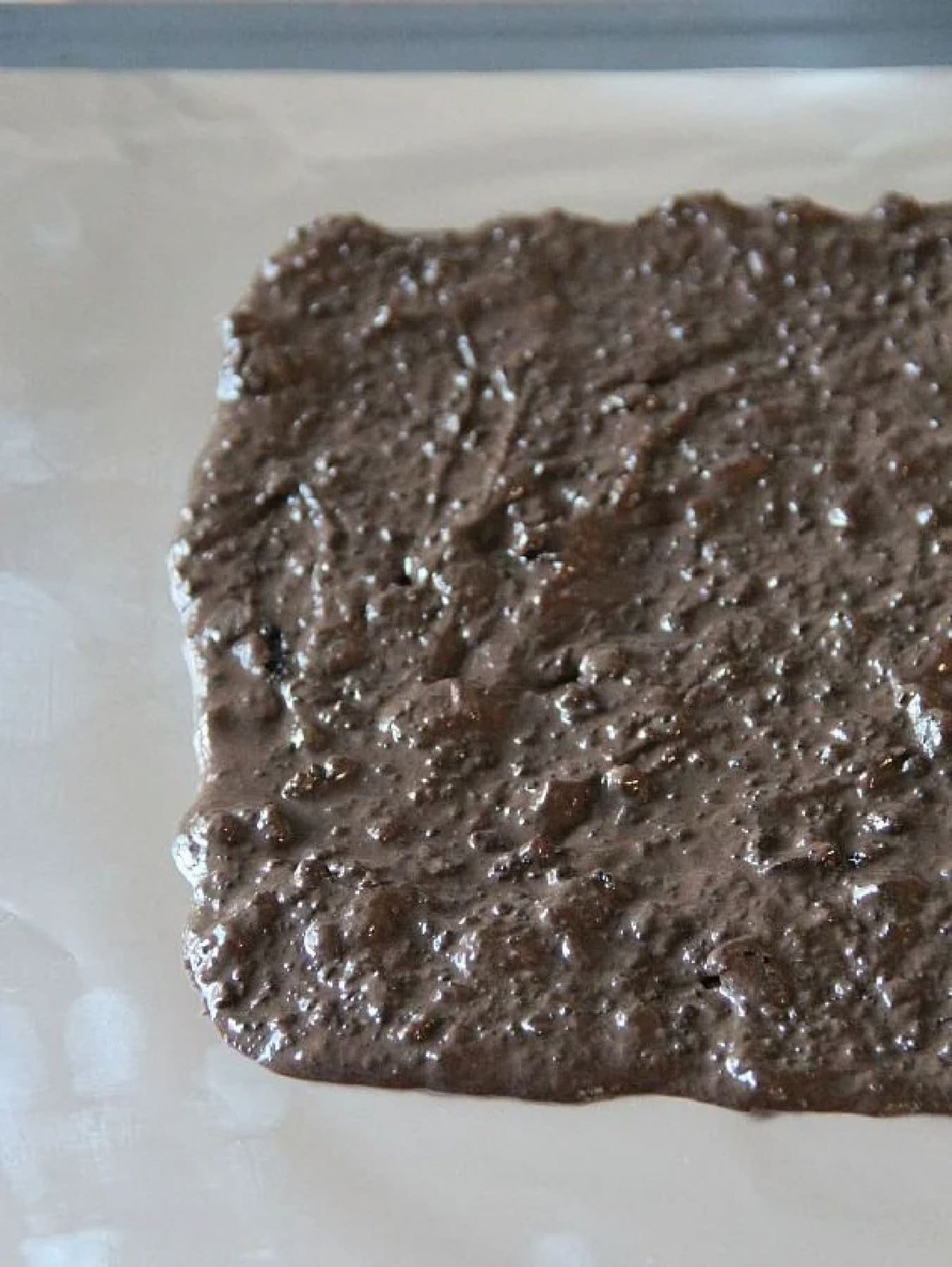 Chocolate oreo mixture spread on a pan and frozen
