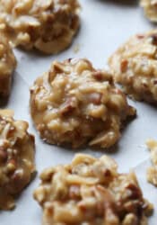 A close up of coconut pralines on a lined pan setting up.