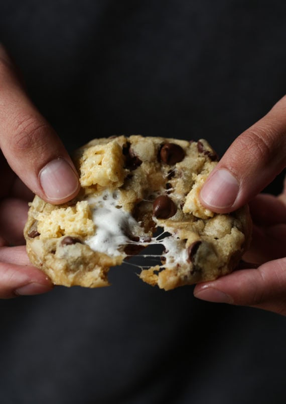 Gooey marshmallow chocolate chip cookie being pulled in half