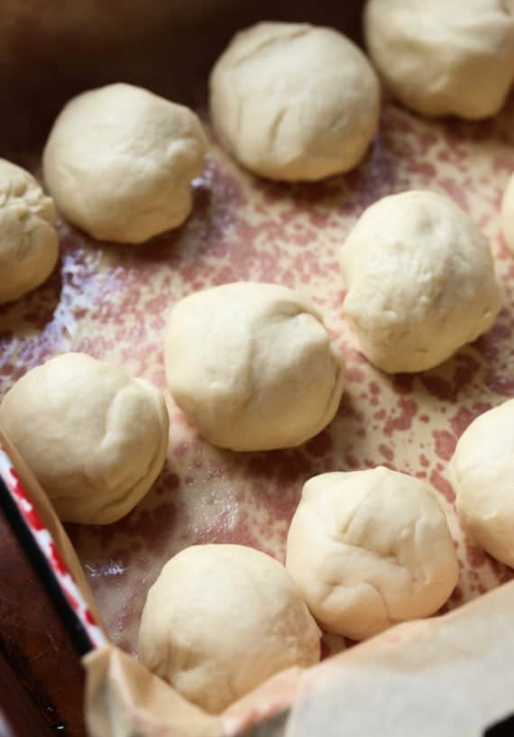 Unbaked dinner roll dough on a baking sheet.