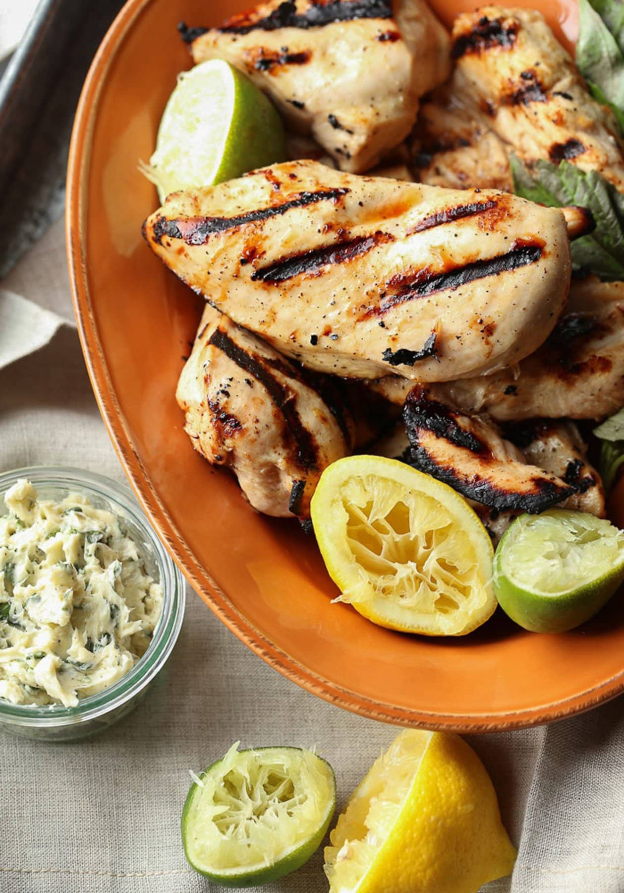 Honey Citrus Grilled Chicken served with basil butter and lemons