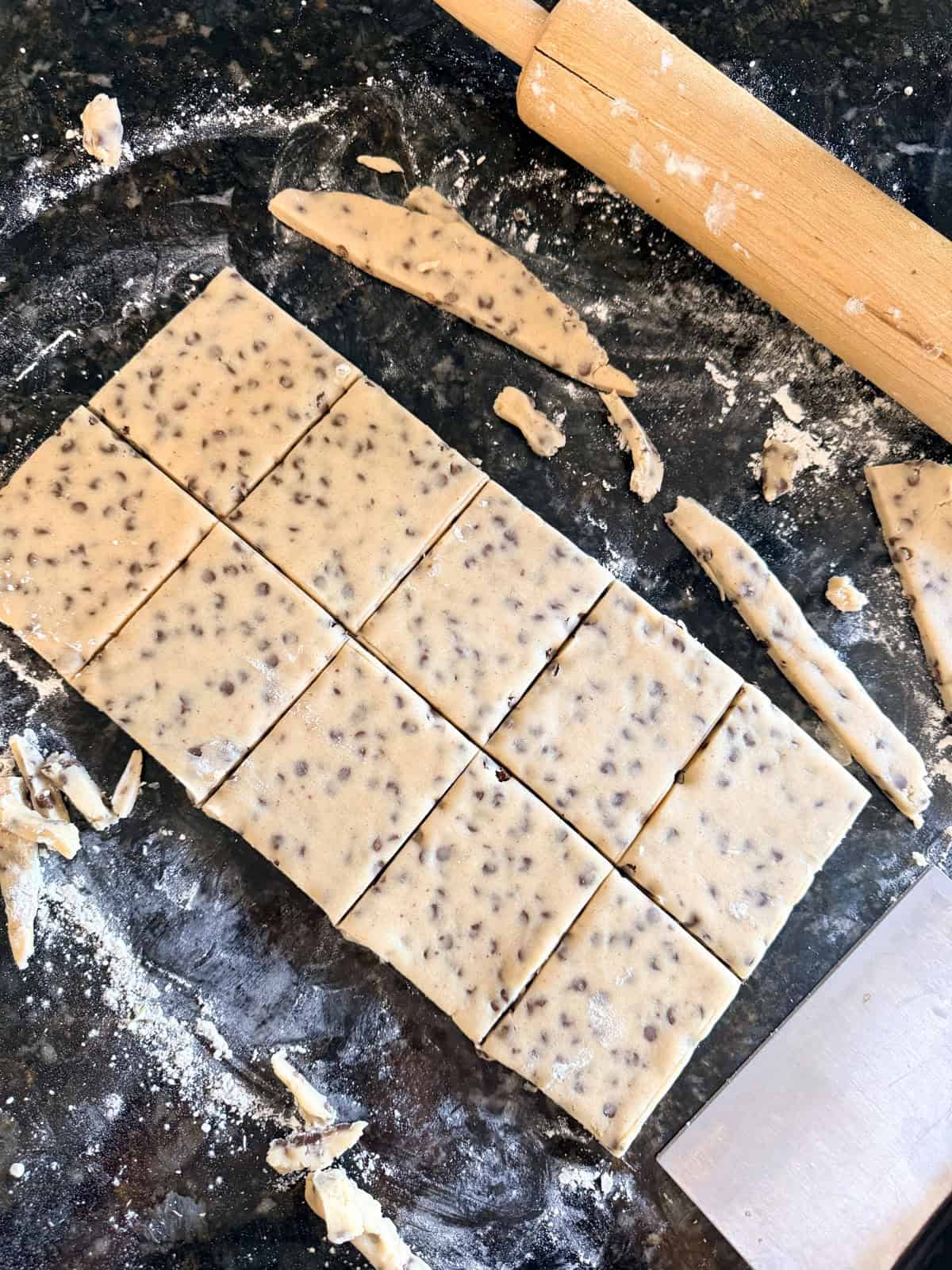 This easy chocolate chip shortbread is crisp, buttery, and loaded with mini chocolate chips. Freezer-friendly and perfect for holiday baking! Chocolate chip shortbread dough rolled out and cut into squares.