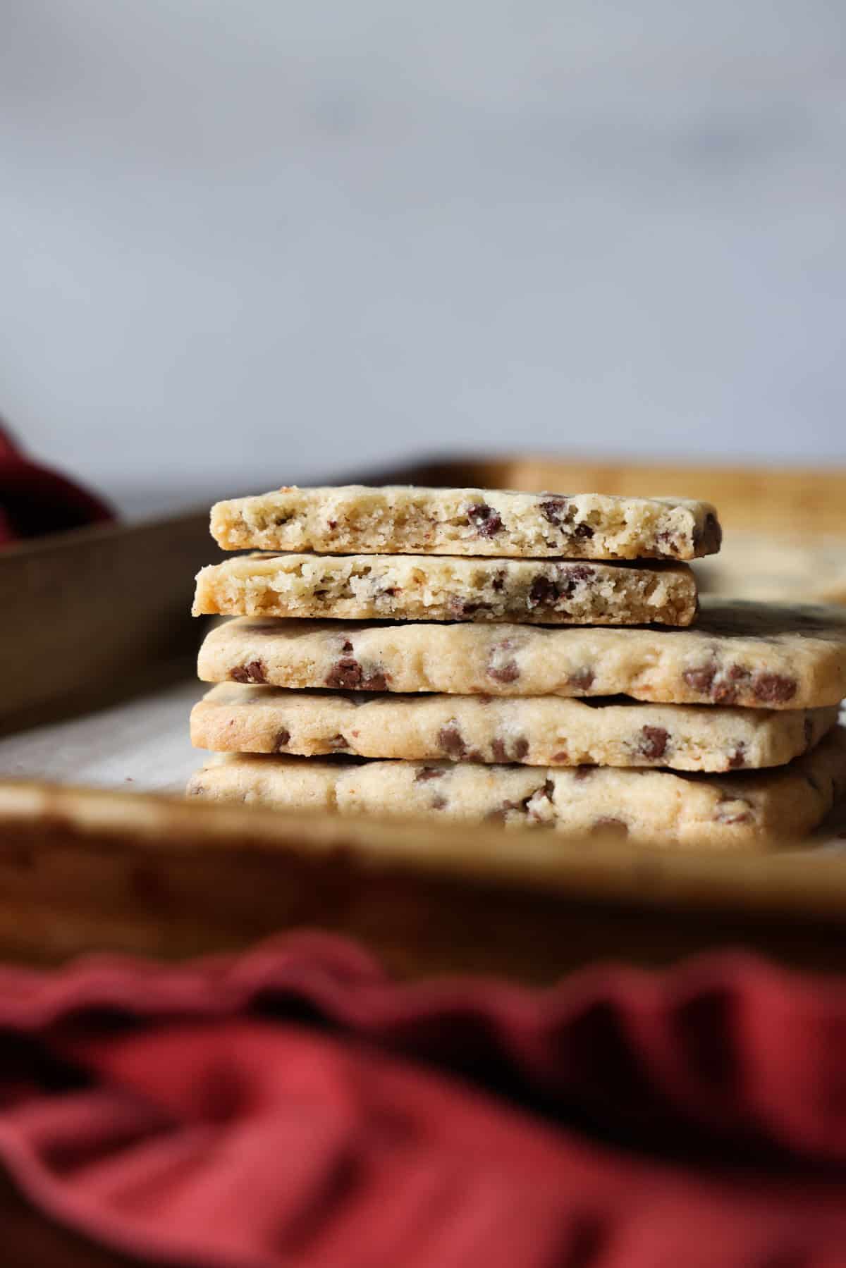 This easy chocolate chip shortbread is crisp, buttery, and loaded with mini chocolate chips. Freezer-friendly and perfect for holiday baking! A stack of chocolate chip shortbread with the top cookie broken in half.