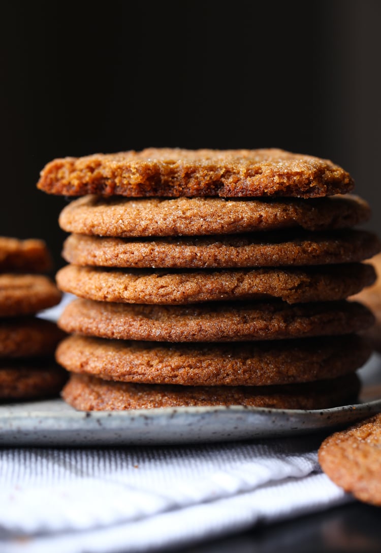 A stack of homemade gingersnap cookies on a plate.