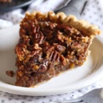 A slice of pecan pie on a white plate