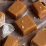 Freshly cut caramel pieces set out on wax paper, waiting to be sprinkled with sea salt and wrapped.