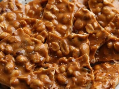 Golden, caramelized homemade peanut brittle served on a plate.