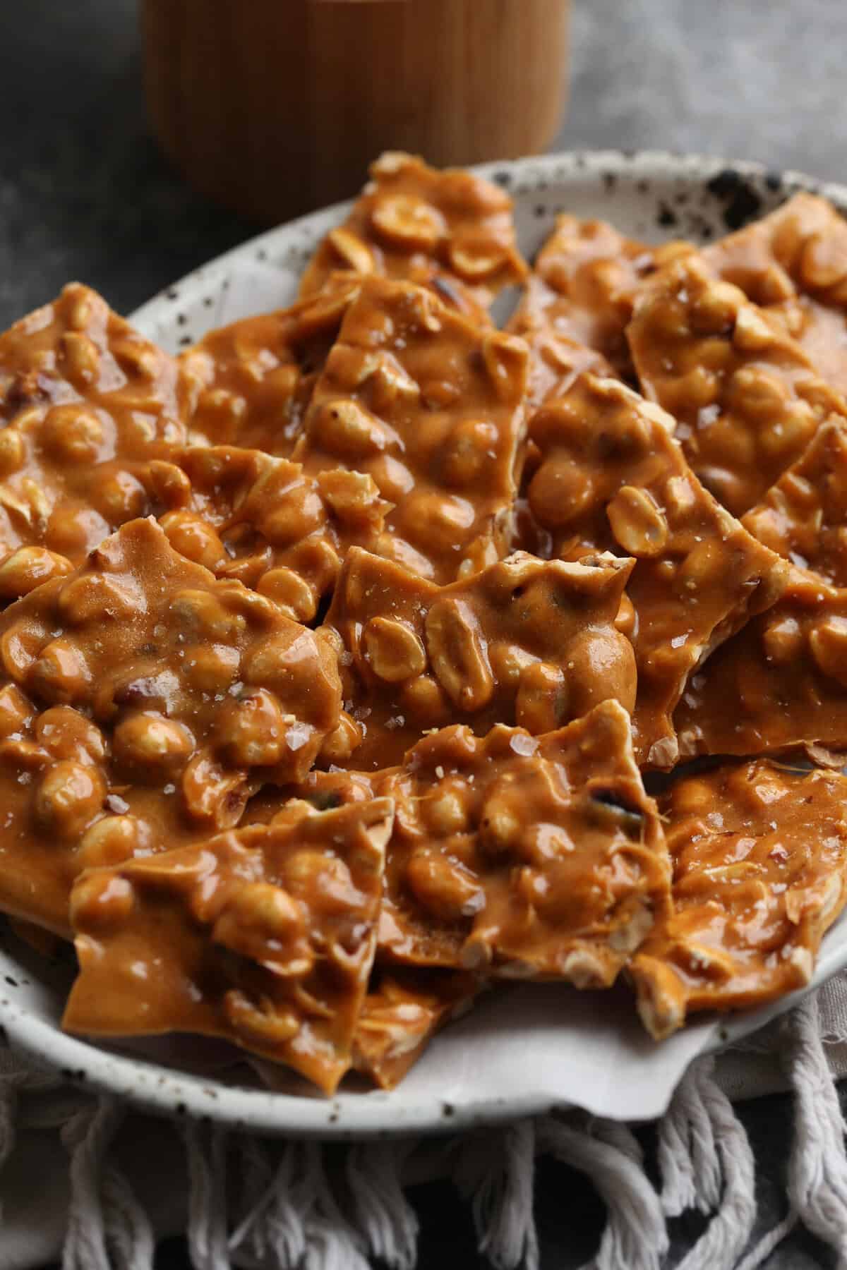 Golden, caramelized homemade peanut brittle served on a plate.