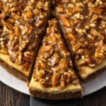 Overhead view of a slice of pecan pie cheesecake cut from the rest of the cheesecake.