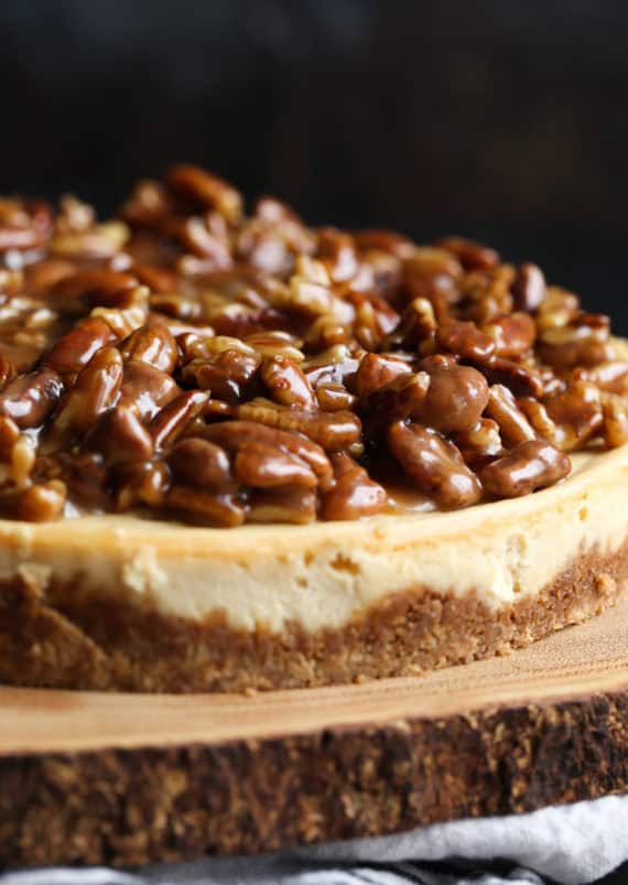 Homemade pecan pie cheesecake on a wooden serving platter