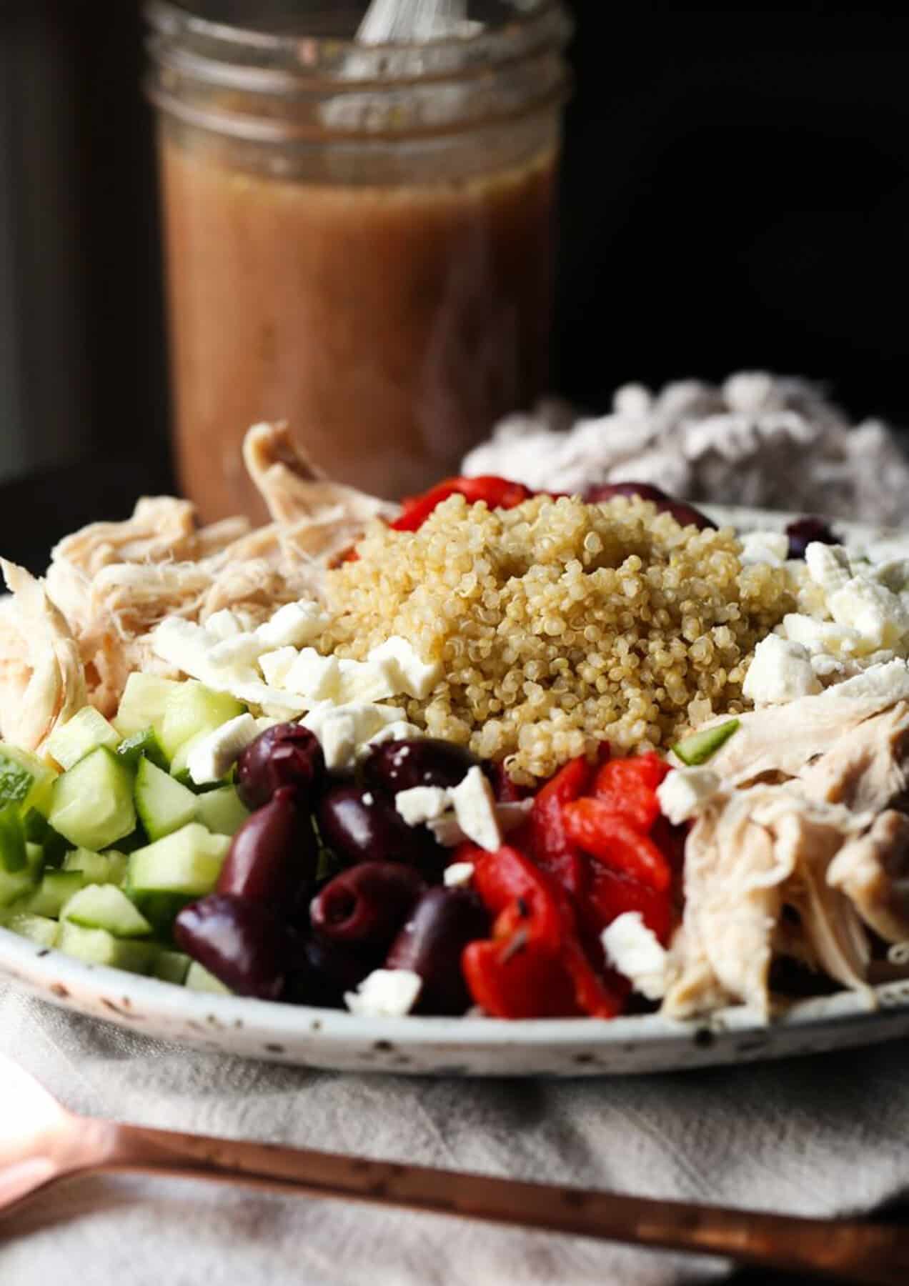 Greek Quinoa Salad displayed on a plate with a dressing 