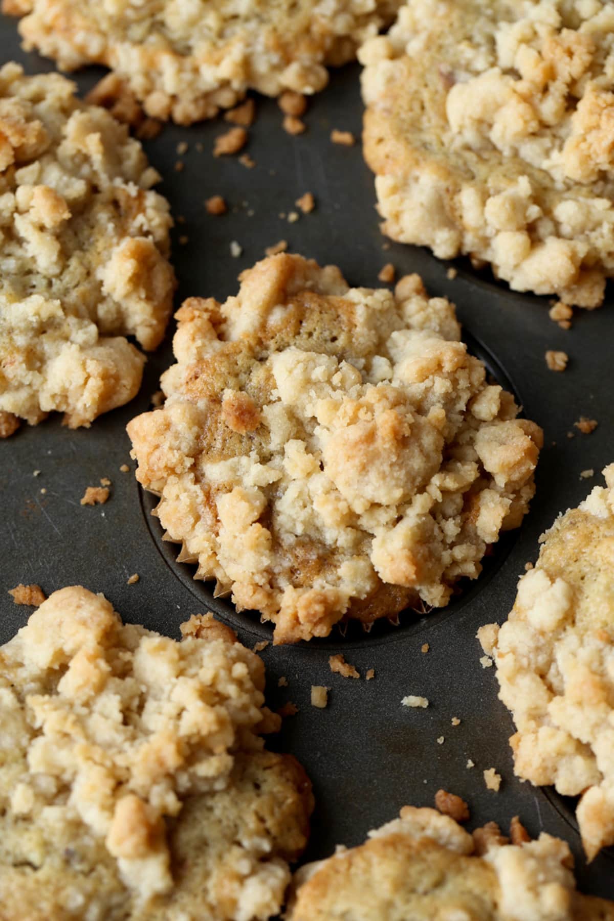 Baked banana muffin topped with streusel in a muffin mold