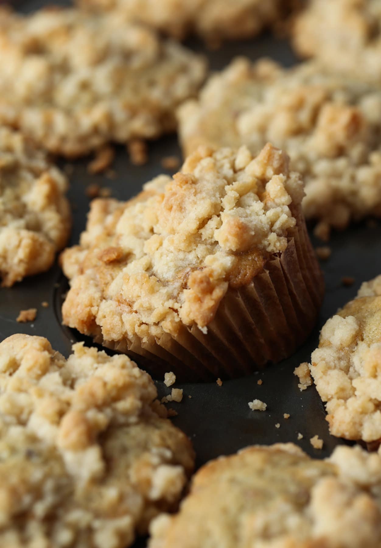 A banana muffin in a muffin pan being removed after baking