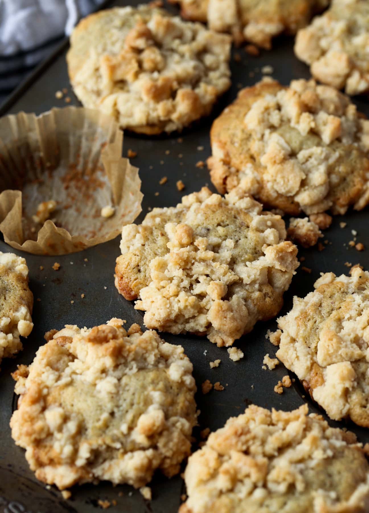 Bananenmuffins mit Krümelbelag in einer Muffinform mit einem leeren Förmchen