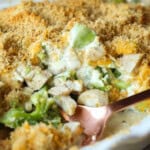 Close up of chicken divan in a casserole dish with a serving spoon.