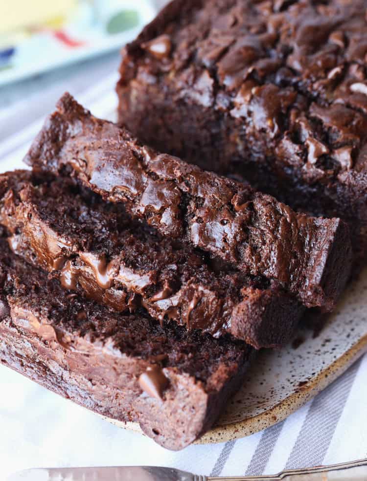 Chocolate banana bread cut into slices on a cutting board.