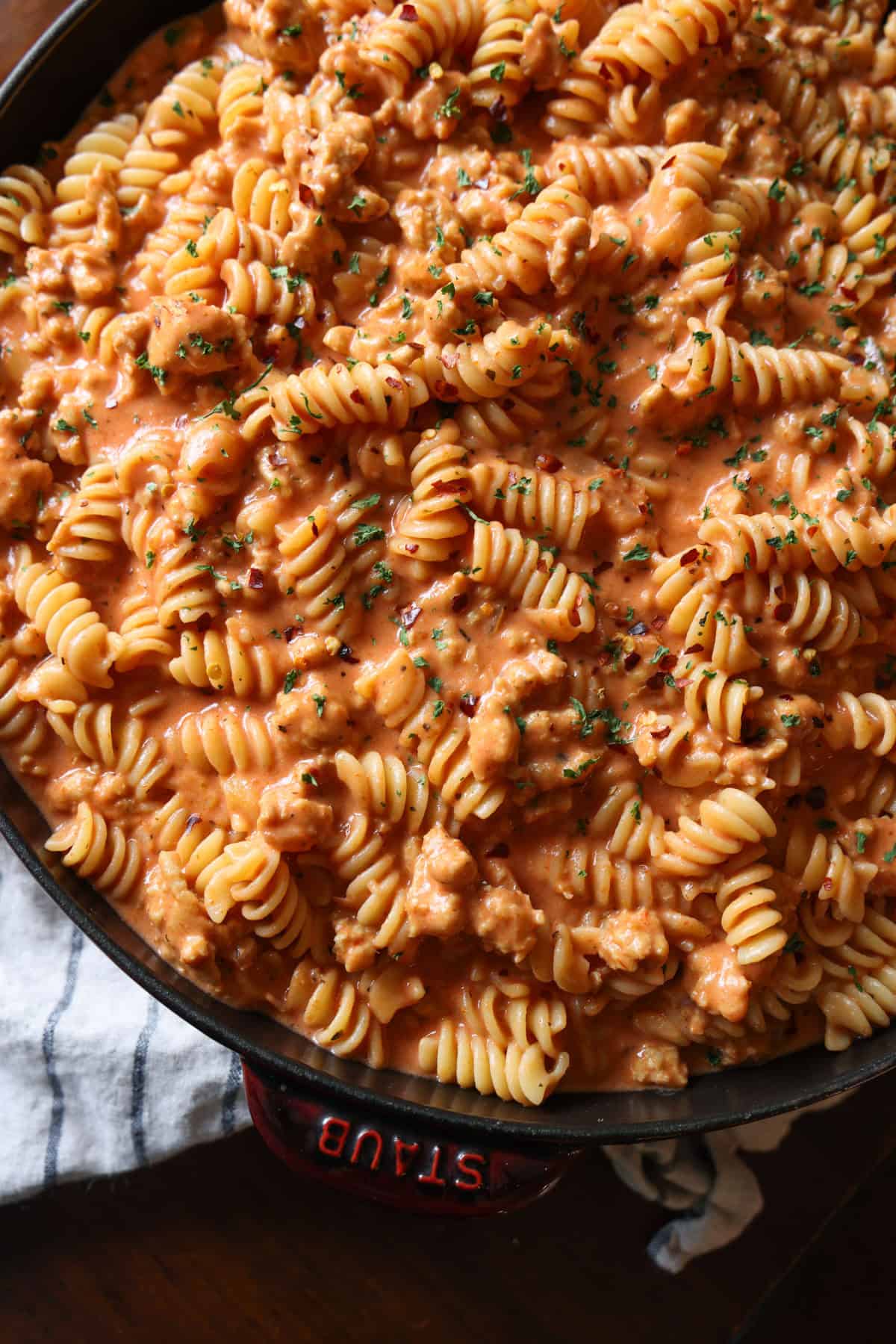 This easy beef pasta recipe is a one-pan dinner made in 30 minutes! Packed with juicy ground beef, cheese, and pasta in creamy tomato sauce. Creamy beef pasta in a skillet.