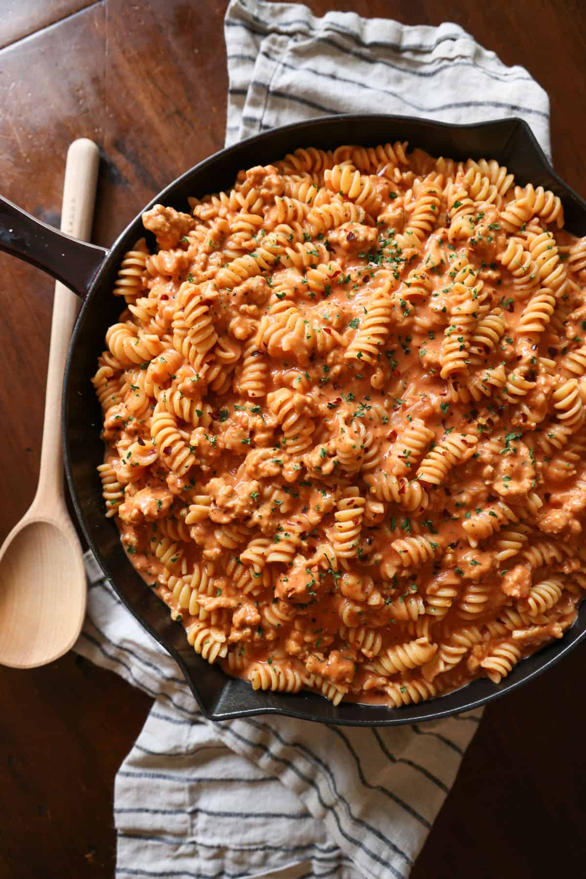 This easy beef pasta recipe is a one-pan dinner made in 30 minutes! Packed with juicy ground beef, cheese, and pasta in creamy tomato sauce. Creamy beef pasta in a skillet.