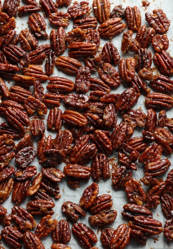 Overhead view of candied pecans spread out in a single layer.